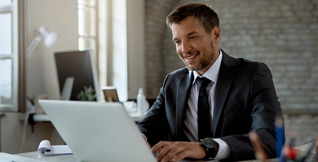 Man smiling and looking at laptop
