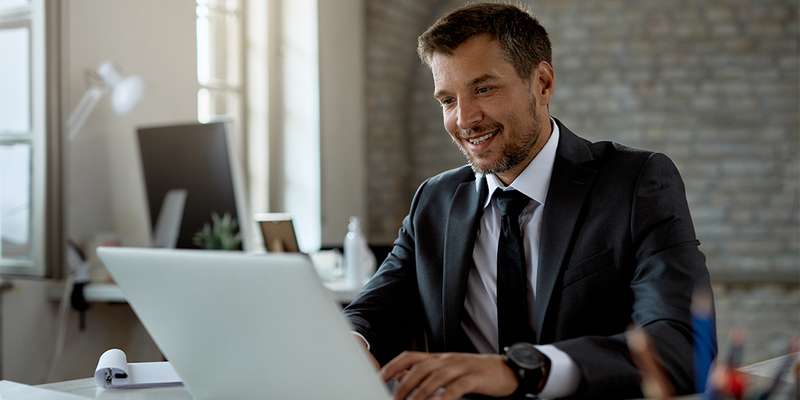 Man smiling and looking at laptop