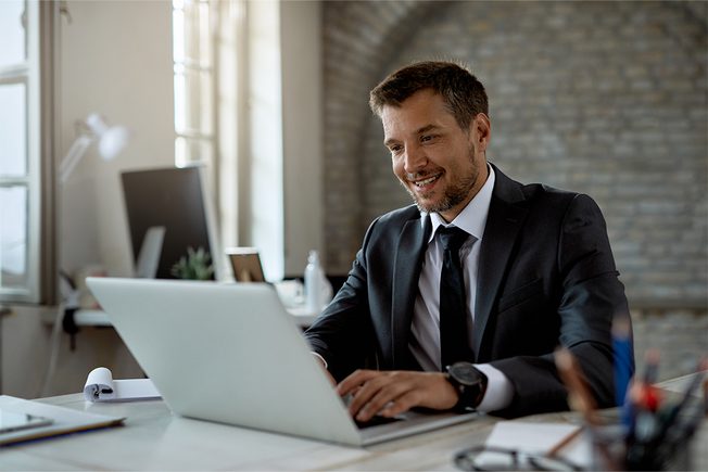 Man smiling and looking at laptop