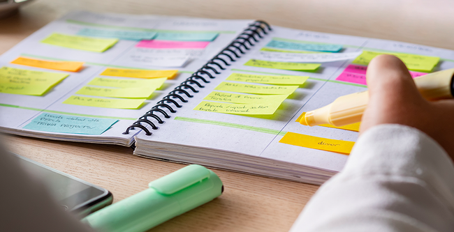 notebook with person highlighting and sticky notes