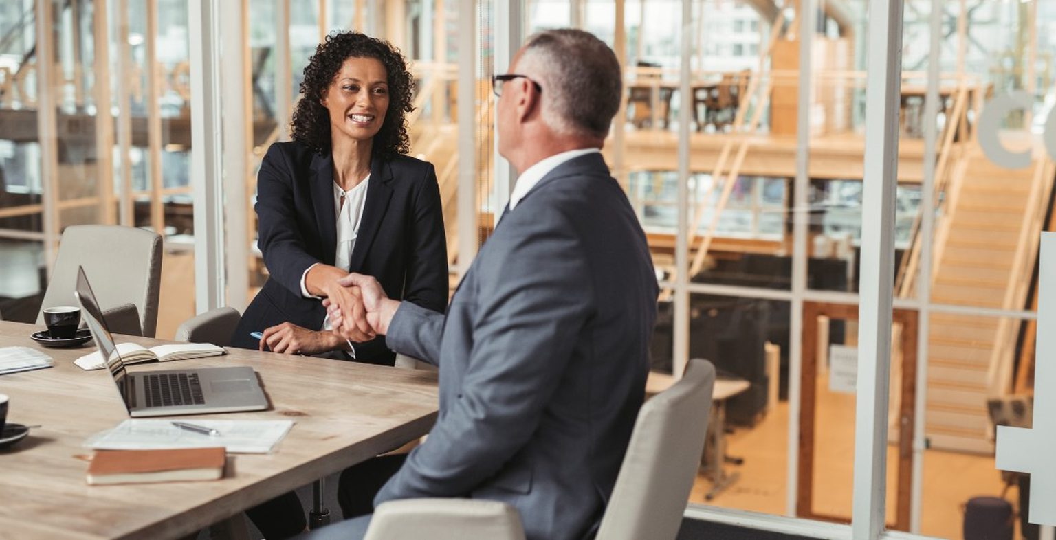 Lawyers shaking hands at a office meeting table