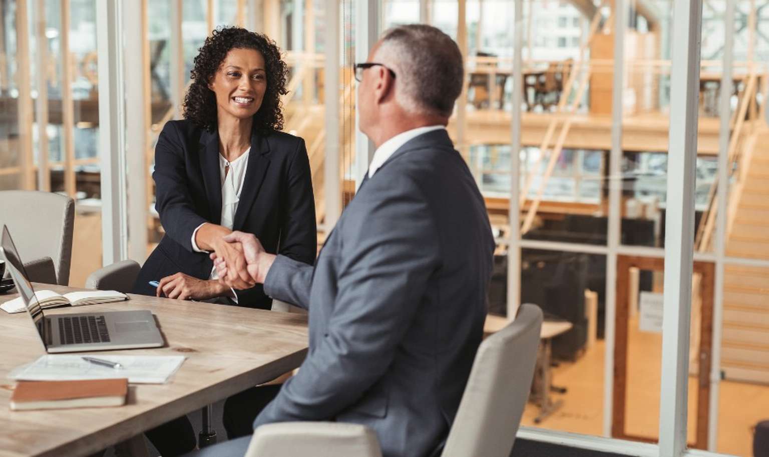 Lawyers shaking hands at a office meeting table