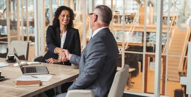 Lawyers shaking hands at a office meeting table