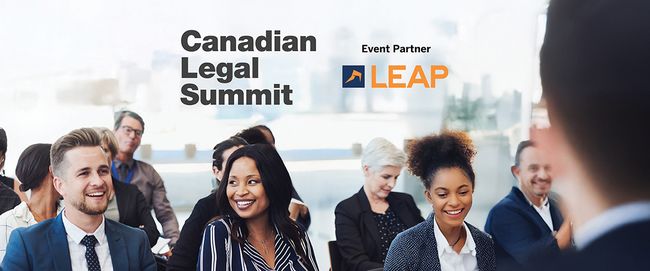 A diverse group of people smiling and sitting in a conference room at the Canadian Legal Summit, with LEAP as an event partner.