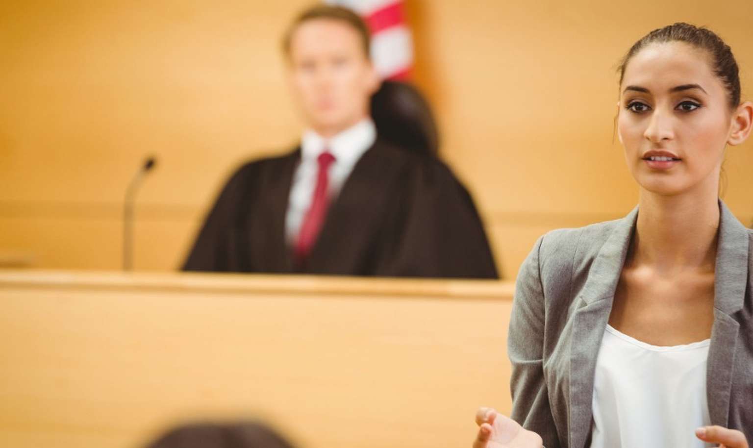 lawyer in a court room with judge in background