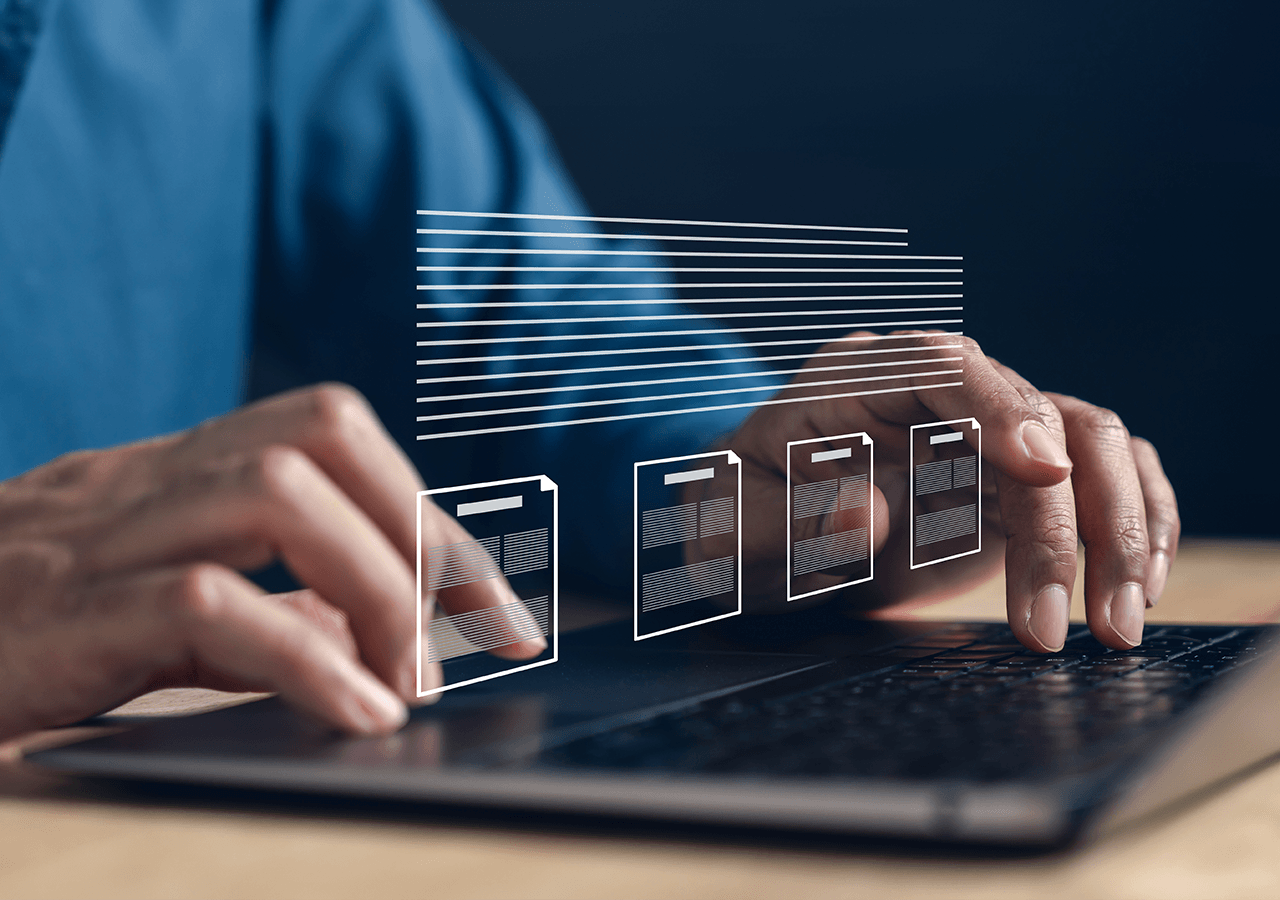 Hands typing on a laptop with digital file icons hovering above the keyboard, symbolizing online document management.