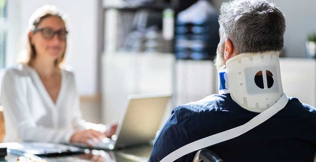 injured man with neckband speaking with a lady lawyer