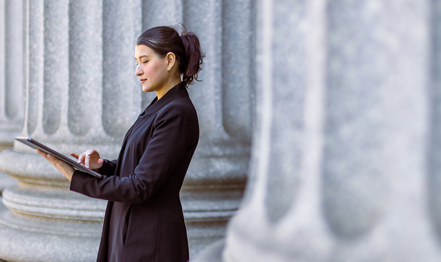 woman lawyer looking at papers outside courthouse