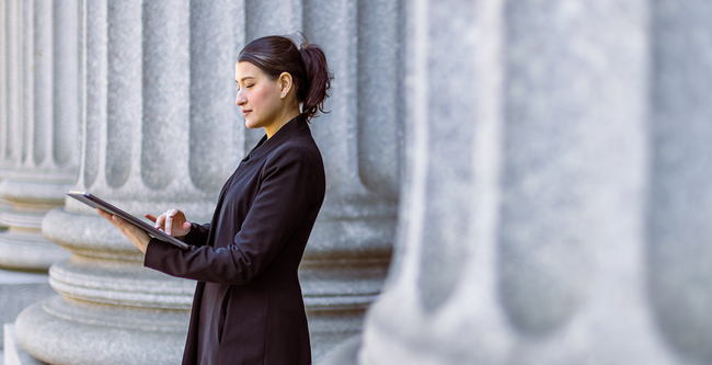 woman lawyer looking at papers outside courthouse
