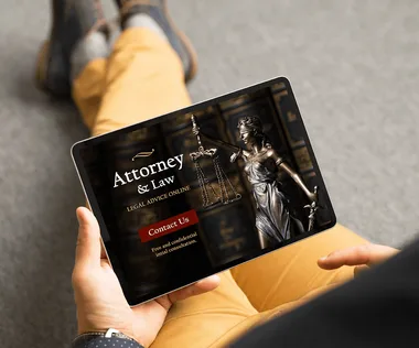 Person holding a tablet displaying a legal website with an image of Lady Justice and options for contacting an attorney.