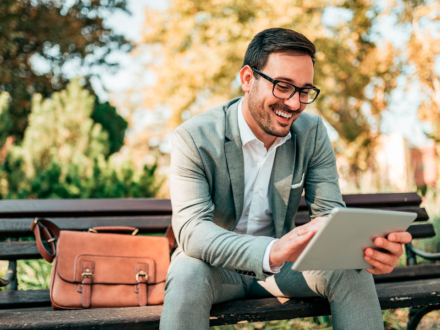 man smiling using leap software on a tablet at a park