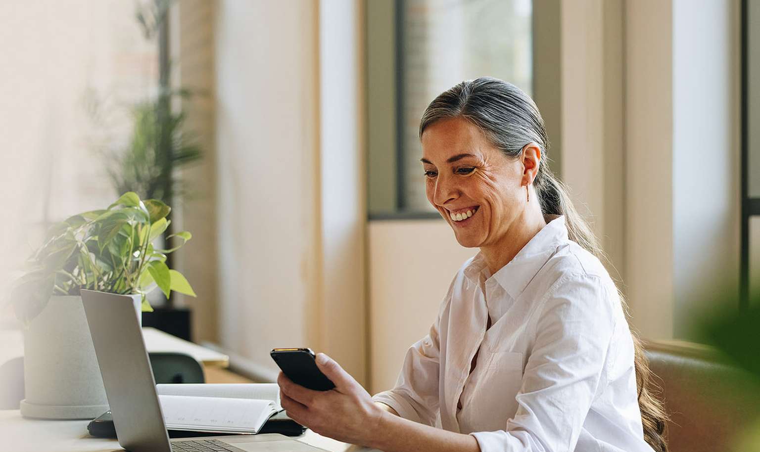 woman lawyer on laptop using leap software holding phone