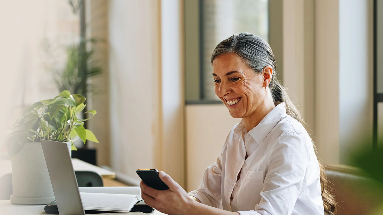 woman lawyer on laptop using leap software holding phone