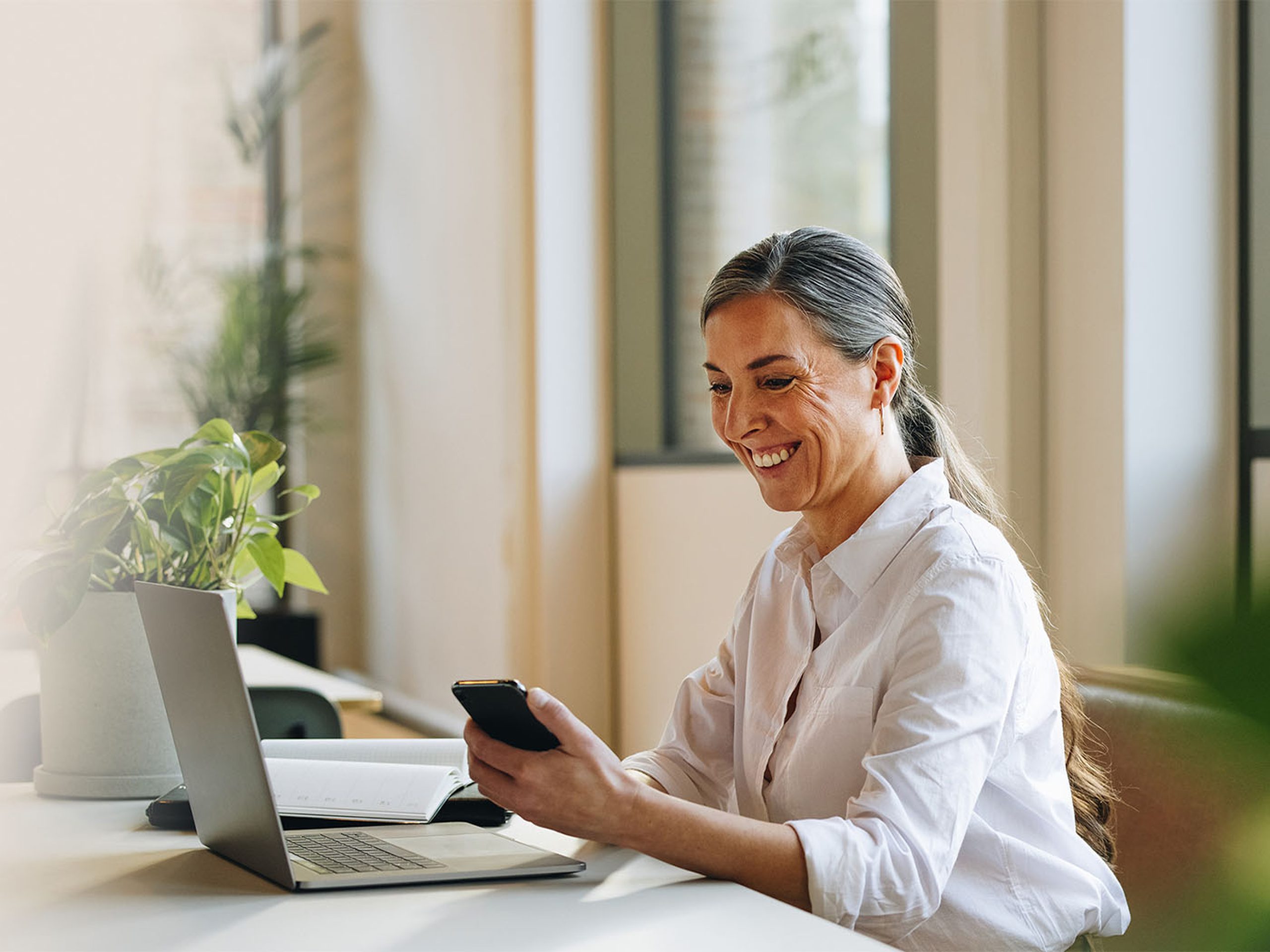 woman lawyer on laptop using leap software holding phone