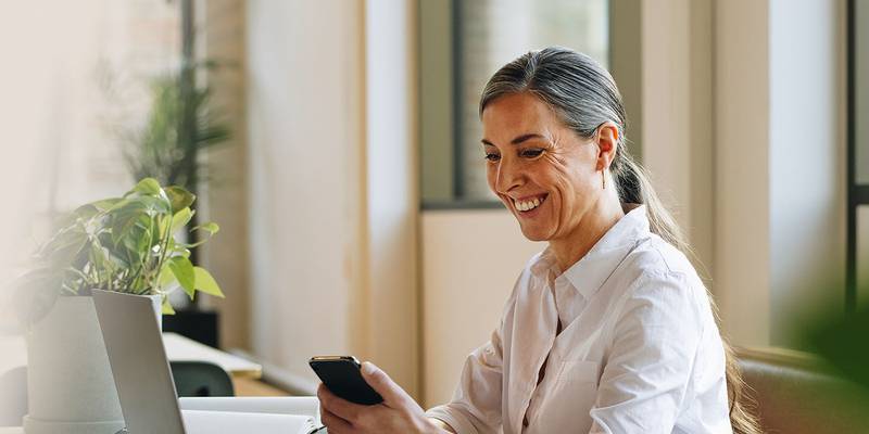 woman lawyer on laptop using leap software holding phone