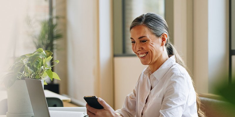 woman lawyer on laptop using leap software holding phone