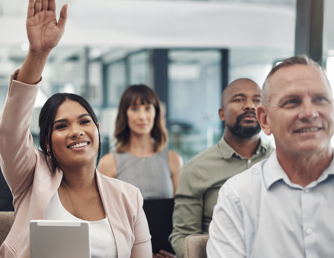 group of people with a hand raised to ask question