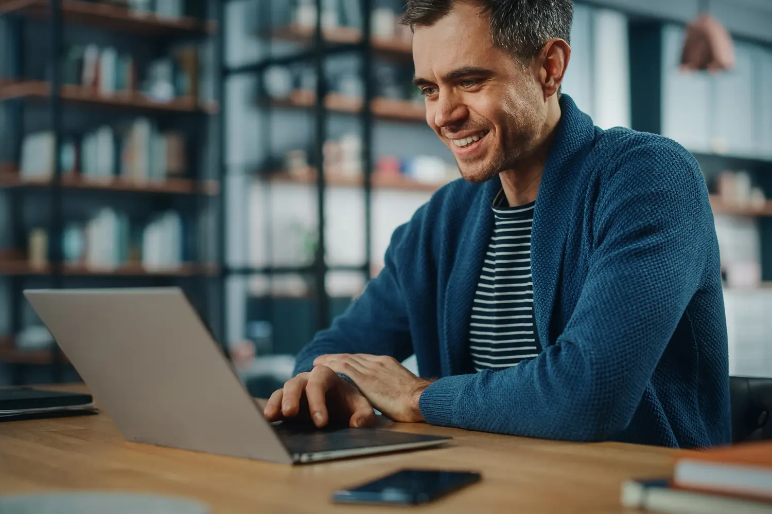 Man smiling and looking down at laptop