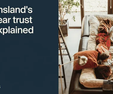 Text reads "Queensland's 125-year trust rule explained" beside an overhead view of two children reading on a large sofa with cushions.