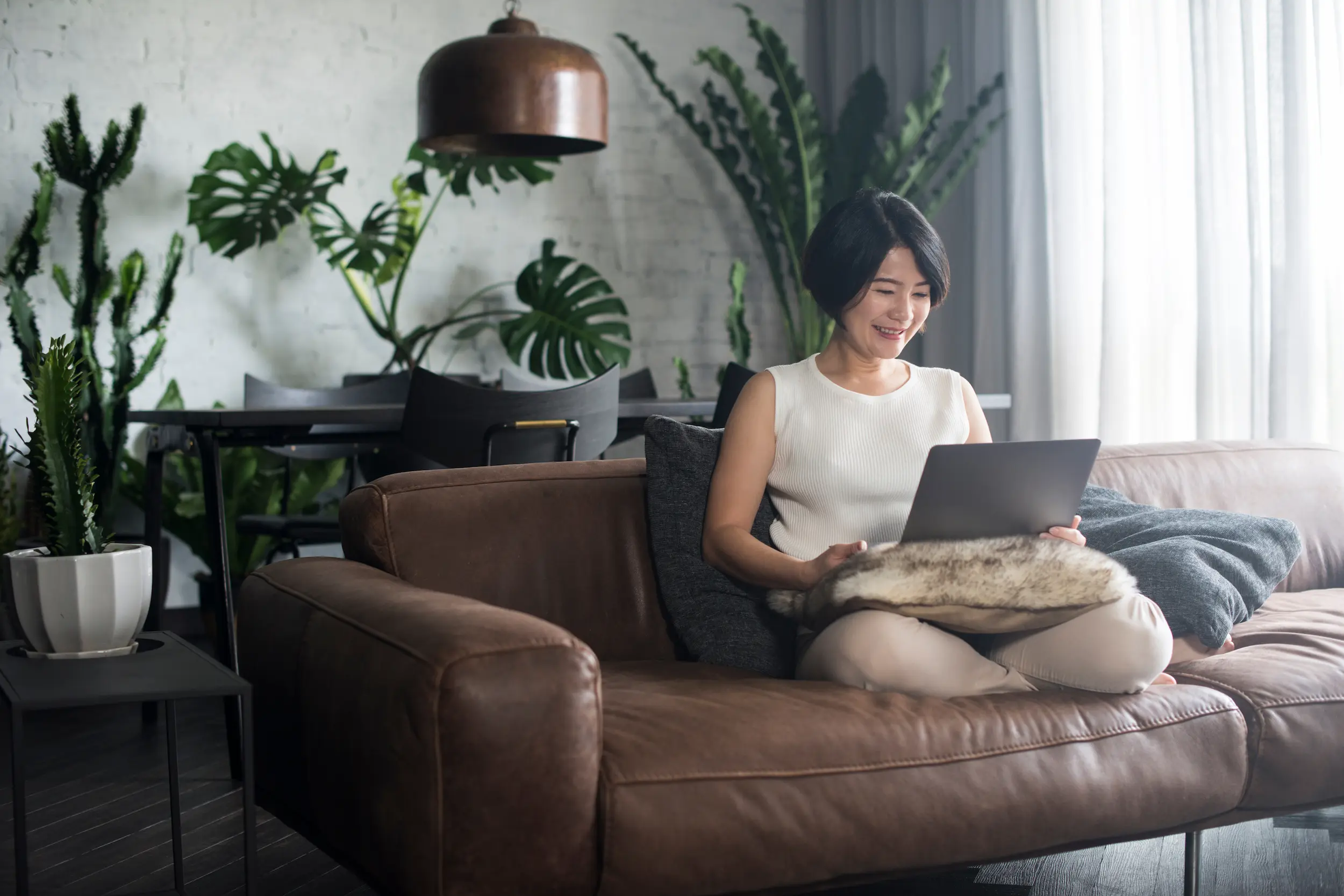 Women sitting on coach looking at laptop