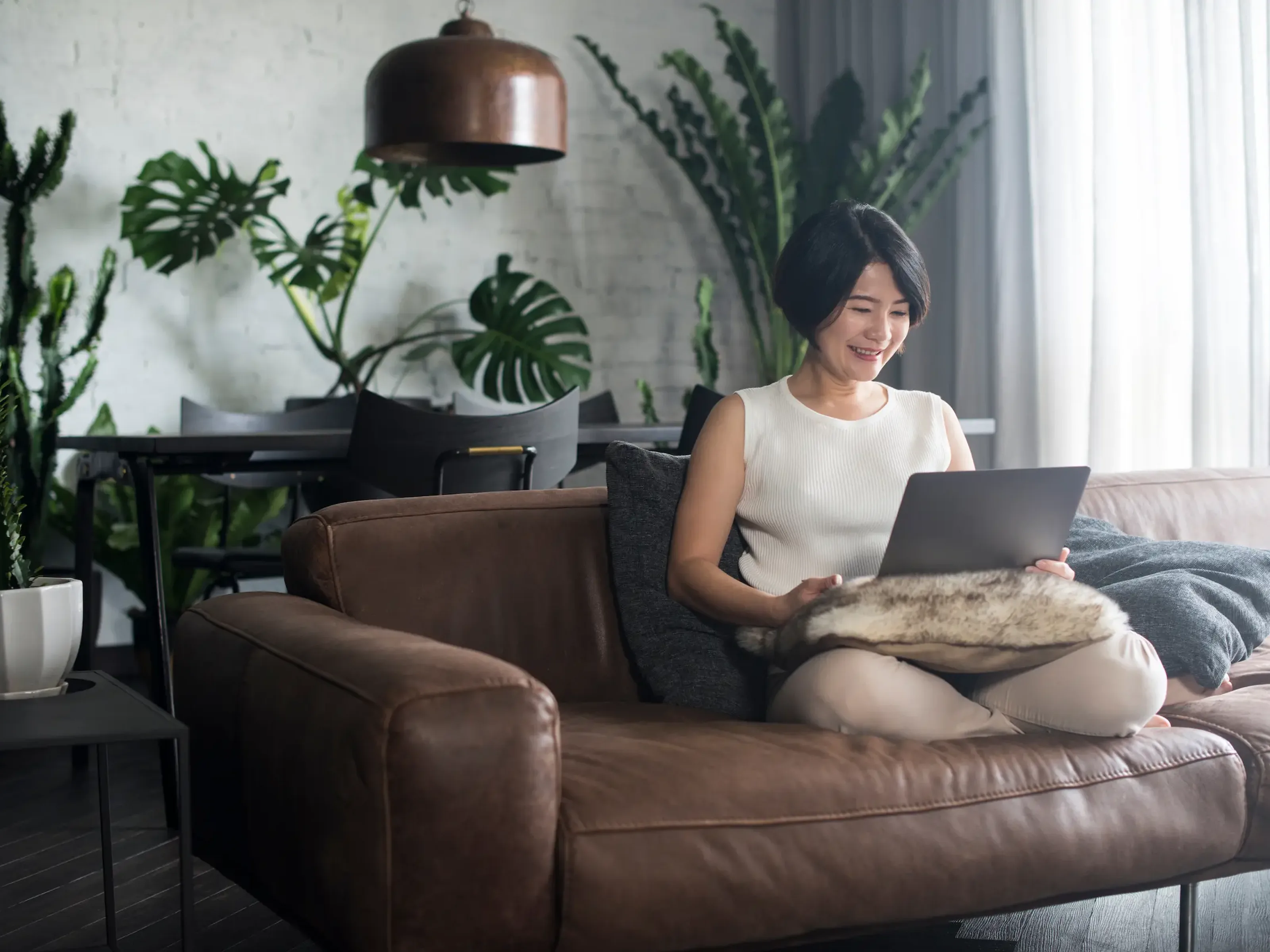 Women sitting on coach looking at laptop