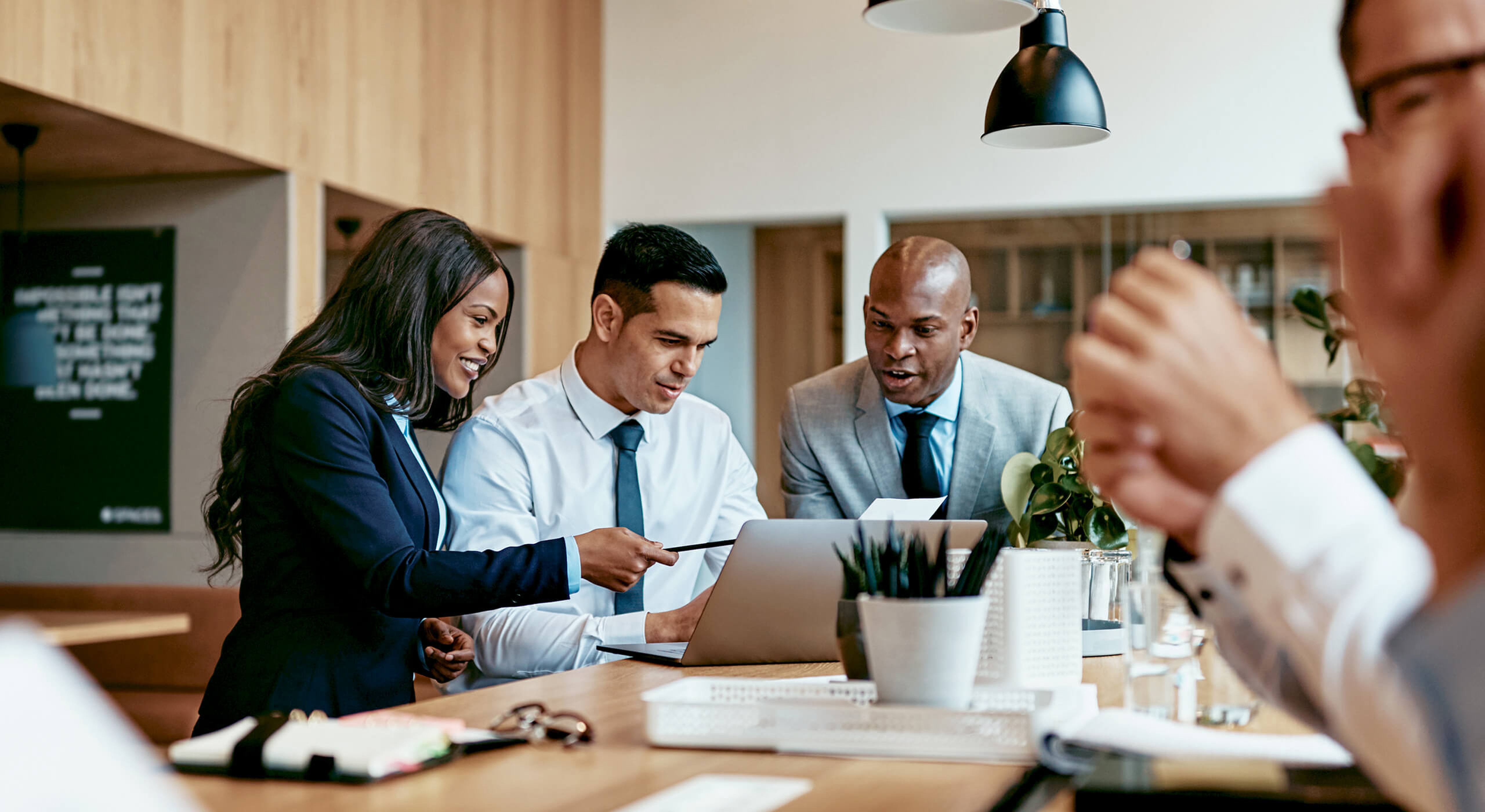 lawyers collaborating around table using laptop