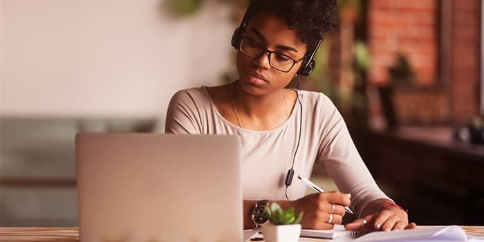 Women with headphones on looking at laptop