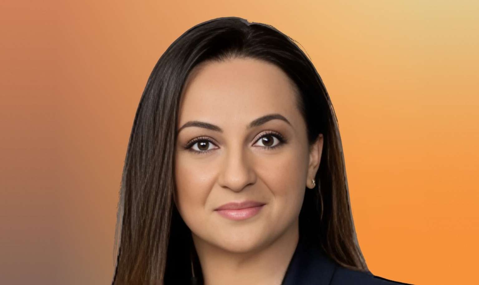 A person with long dark hair and a subtle smile, wearing a dark outfit, against a warm gradient background.