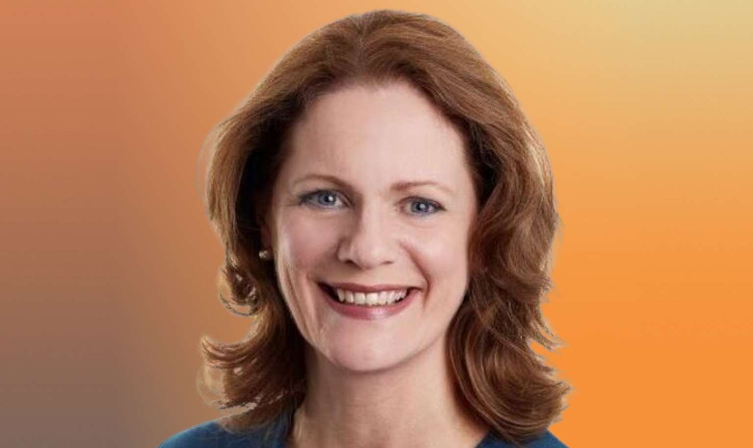 Smiling woman with shoulder-length auburn hair against a gradient orange background.