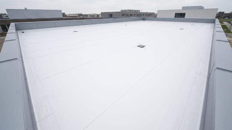 Plat dak met een nieuwe witte EPDM-dakbedekking en een metalen dakrand