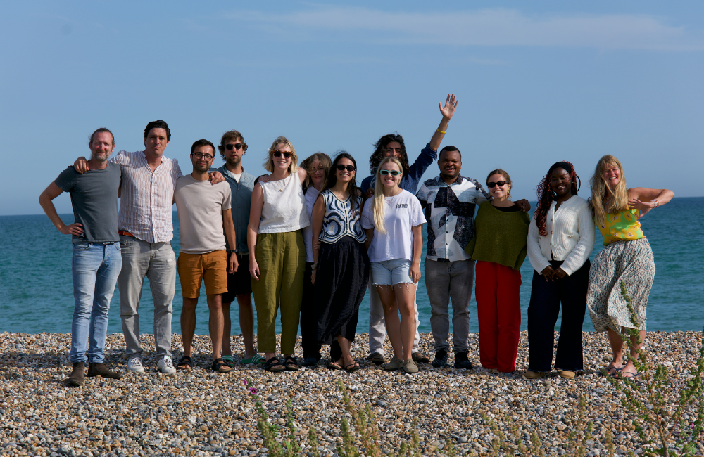 Earthly team posing for a photo by the water during our retreat in 2024