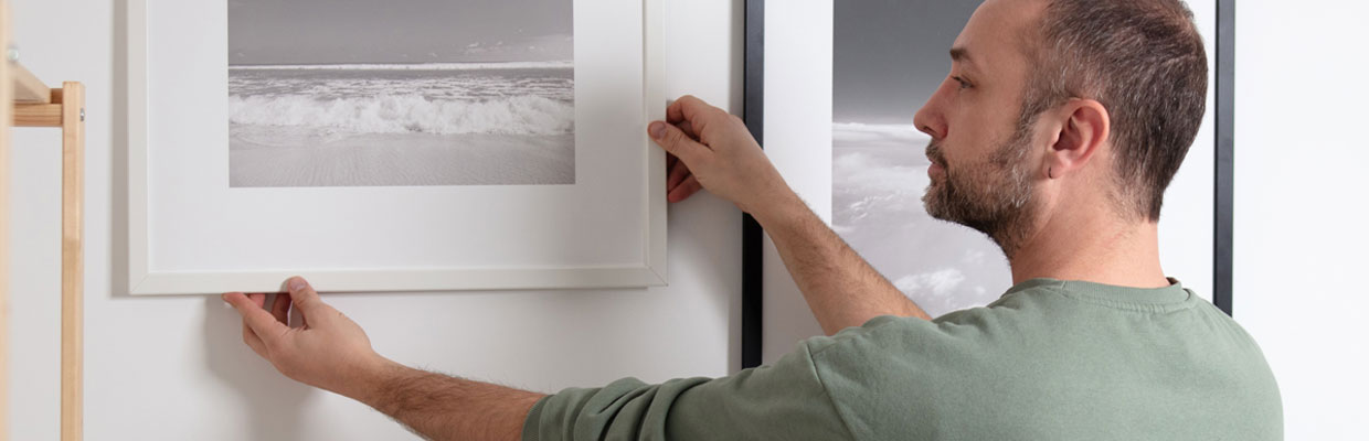 Man hanging picture frames