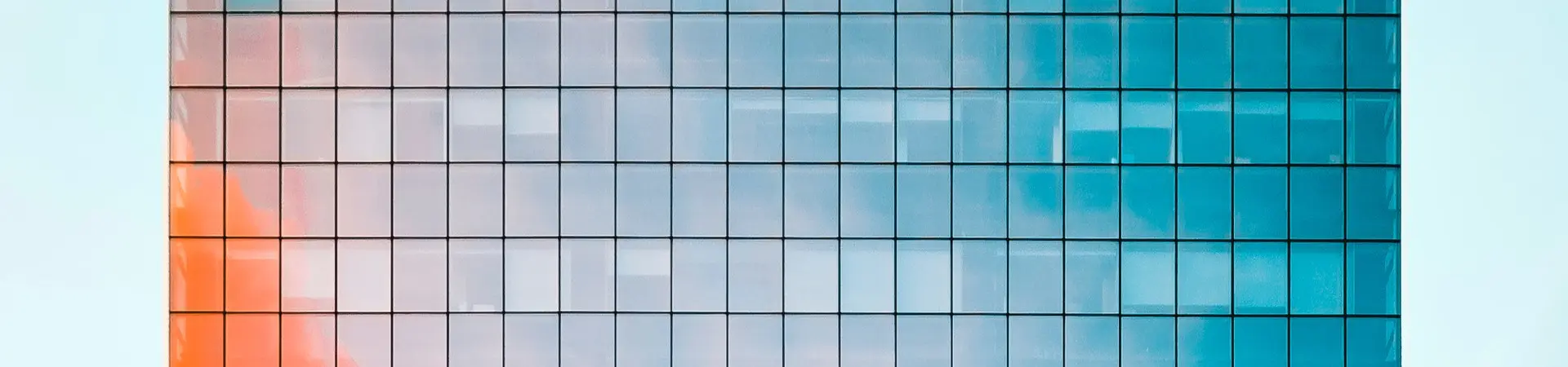 Er wordt een groot kantoor weergegeven met een weerspiegeling op het gebouw van een ander gebouw en van de lucht. 