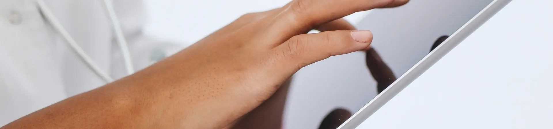 Een dokter met witte doktersjas houdt een grote tablet vast. 