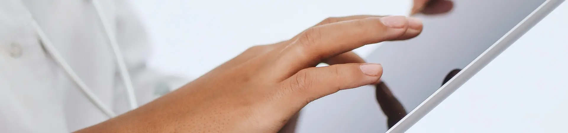 Een dokter met witte doktersjas houdt een grote tablet vast