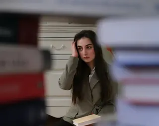 Vrouw die op haar hurken zit met boeken op haar schoot, getuige in strafrecht