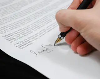 Iemand die een document ondertekend met een vulpen