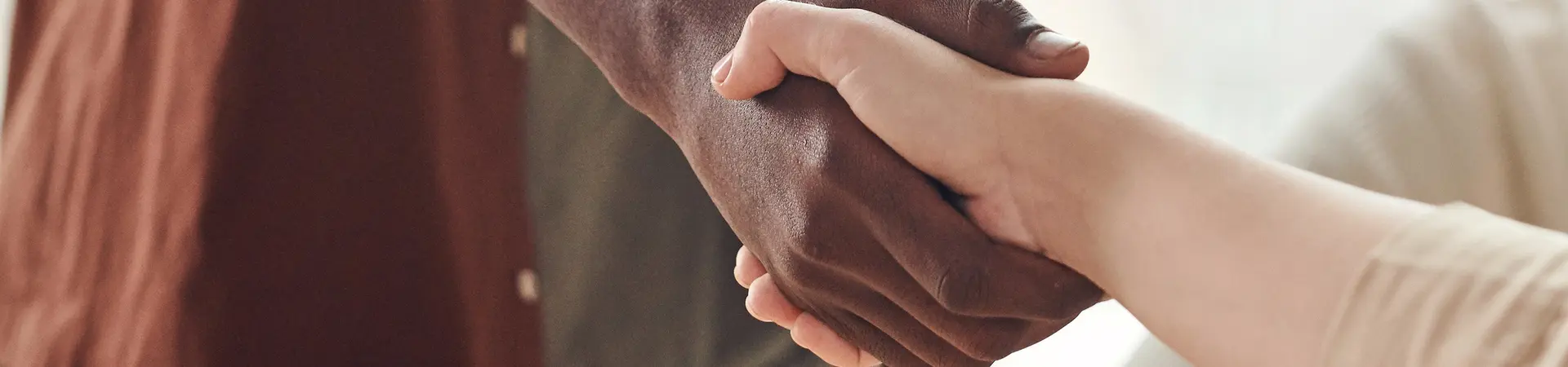 Twee mensen geven elkaar een hand na een online cursus verbintenissenrecht | MR. in opleidingen
