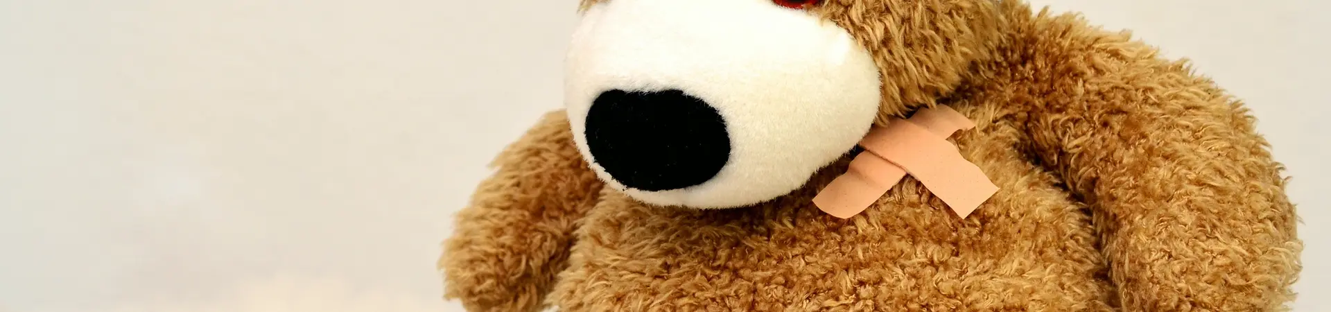 knuffelbeer met verband om zijn hoofd en been en een pleister op zijn borst
