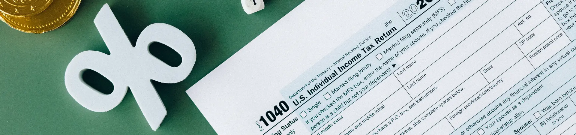 Een fiscaal formulier ligt op een tafel met een tekenmachine, notitieblok en wat munten geld. 