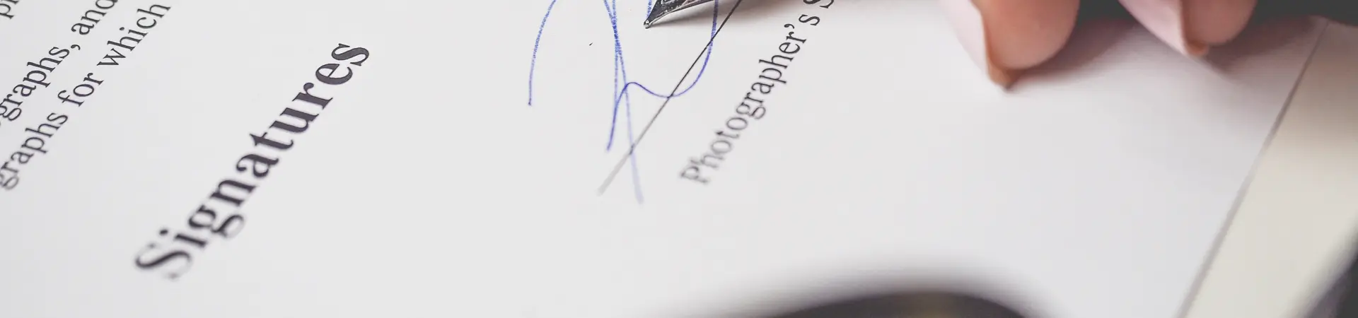 Een contract wordt door een vrouwelijke werknemer van een bedrijf ondertekent met een vulpen. 