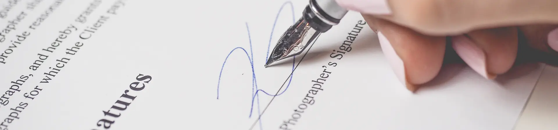 Een contract wordt door een vrouwelijke werknemer van een bedrijf ondertekent met een vulpen. 