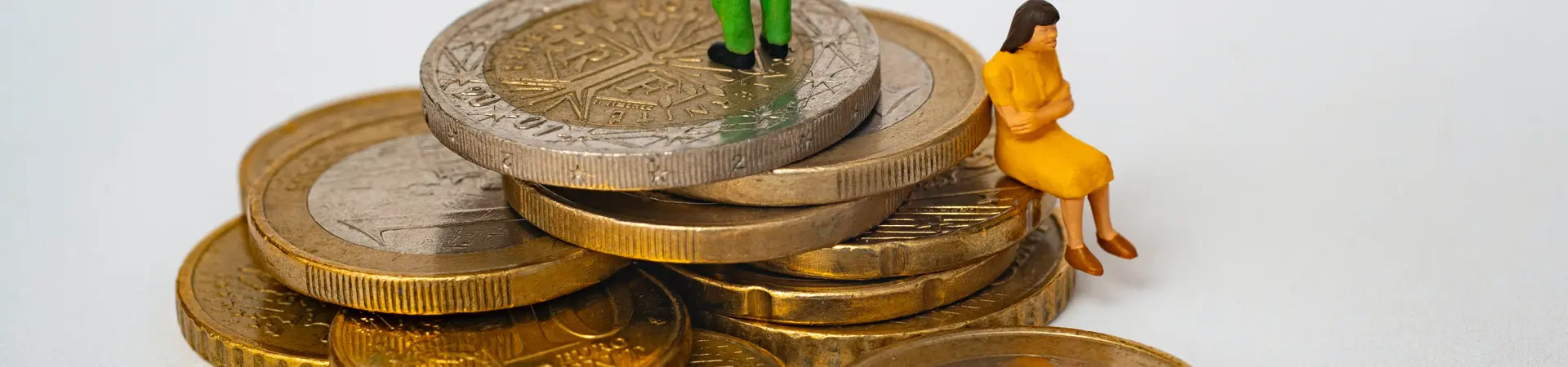 Euro munten met kleine poppetjes erop, dit zijn een man en vrouw die met de ruggen naar elkaar toe staan