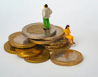 Euro munten met kleine poppetjes erop, dit zijn een man en vrouw die met de ruggen naar elkaar toe staan