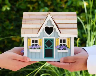 Twee mensen met een houten huisje