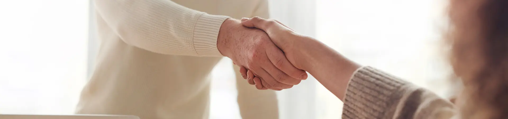 Man en vrouw schudden elkaar de hand op kantoor na het wijzigen van een overeenkomst