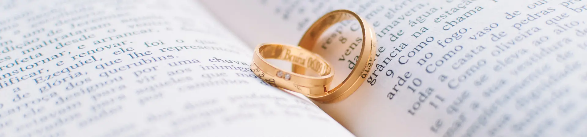 Een boek dat open ligt en in het midden twee gouden trouwringen liggen
