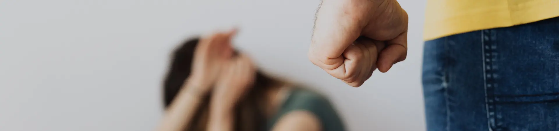 Man met vuist agressief vrouw op achtergrond duikt weg