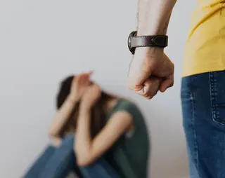 Man met vuist agressief vrouw op achtergrond duikt weg