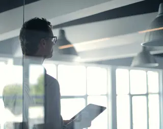 Bestuurder die achter een glazen wand staat